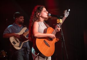 זמרת עם גיטרה על במה